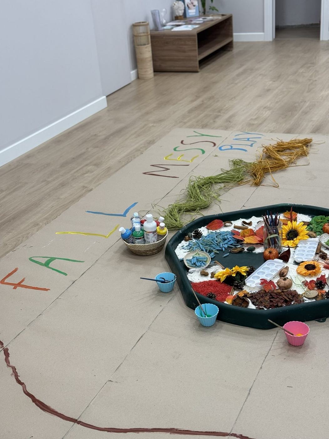 Πινακίδα 'Fall Messy Play' δίπλα σε φθινοπωρινό sensory tray σε παιδικό πάρτι