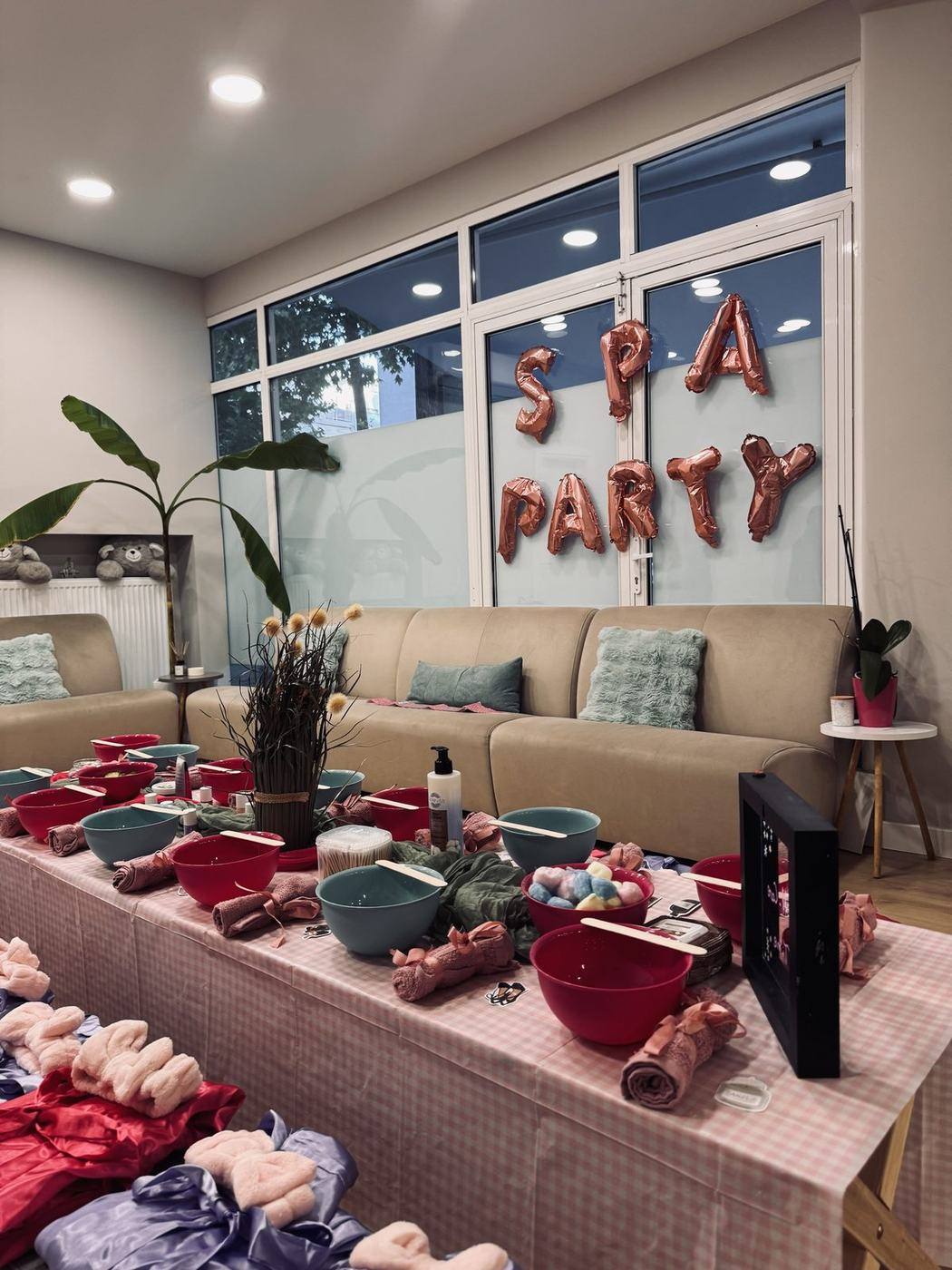 Λεπτομέρεια boutique spa party: τραπέζι με μπολ σε φούξια και μέντα, πετσετάκια με κορδέλα, αποξηραμένα λουλούδια και ρόμπες