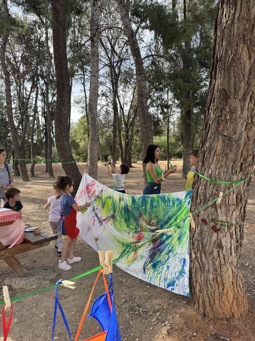 Παιδιά κάνουν action painting σε καμβά σε εξωτερικό χώρο πάρτι